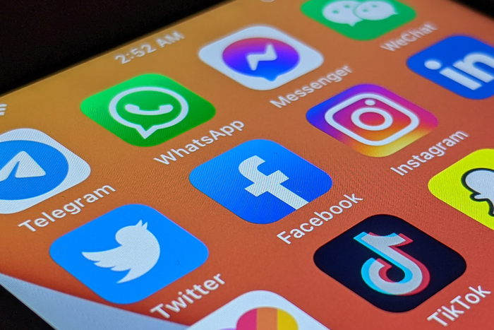 A close-up of a smartphone with various social media apps installed.